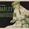 Original 1948 Harley Davidson vintage motorcycle poster featuring pin-up illustration of woman on motorcycle, green and black lithograph, linen-backed, horizontal format, "World's Most Popular Motorcycles" tagline, brochure-cover art, ready to frame.
