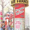 A lively Paris street scene unfolds around a Morris column wrapped in Air France advertisements, transforming an everyday corner into a moment of celebration. The column rises at the center of the composition, layered with bold red panels and crisp lettering that immediately draw the eye, while the surrounding city softens into a gentle, atmospheric backdrop.