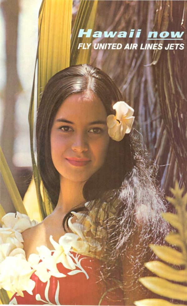 Portrait of a woman with a flower in her hair surrounded by tropical foliage against a soft natural background.
